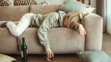 mujer con guayabo, acostada en un mueble, luego de tomar whiskey