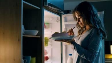 mujer hambrienta comiendo un aperitivo de medianoche / antojos de dulce