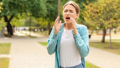 Mujer joven con alergia al aire libre / estornudo / Estornudar