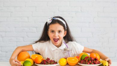 ni&ntilde;a con muchas frutas sobre una mesa