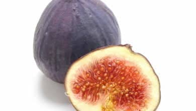 un higo cortado por la mitad sobre fondo blanco