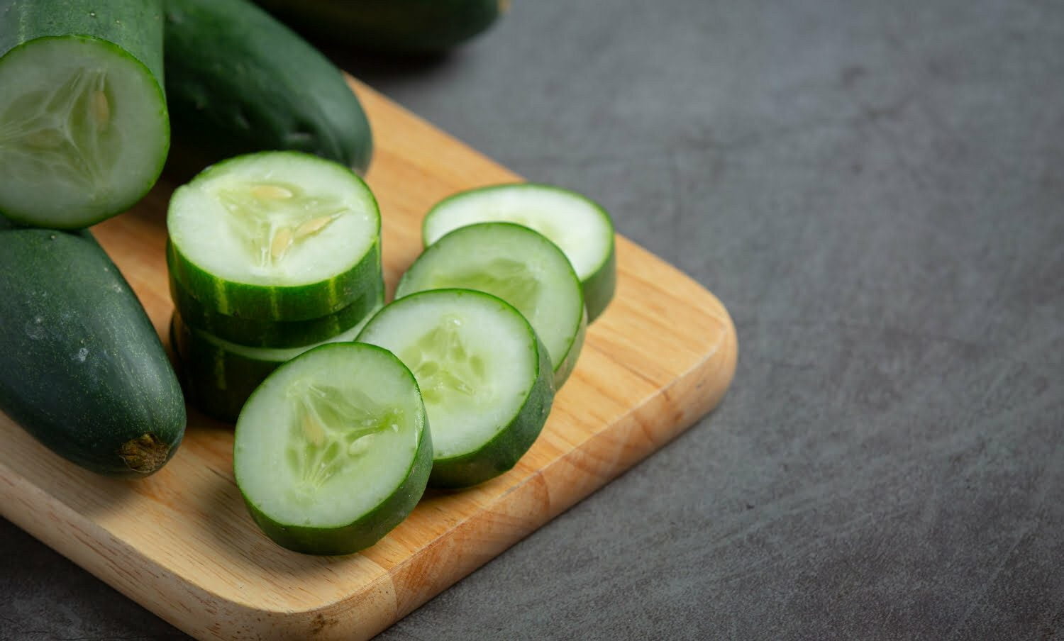 rodajas frescas de pepino sobre tabla de madera