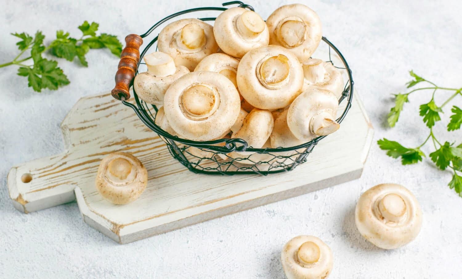 champi&ntilde;ones blancos en cesta, sobre una tabla, listos para preparar