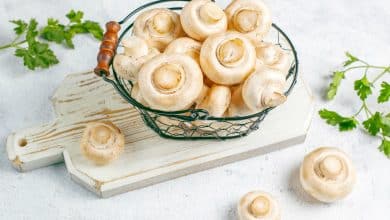 champi&ntilde;ones blancos en cesta, sobre una tabla, listos para preparar