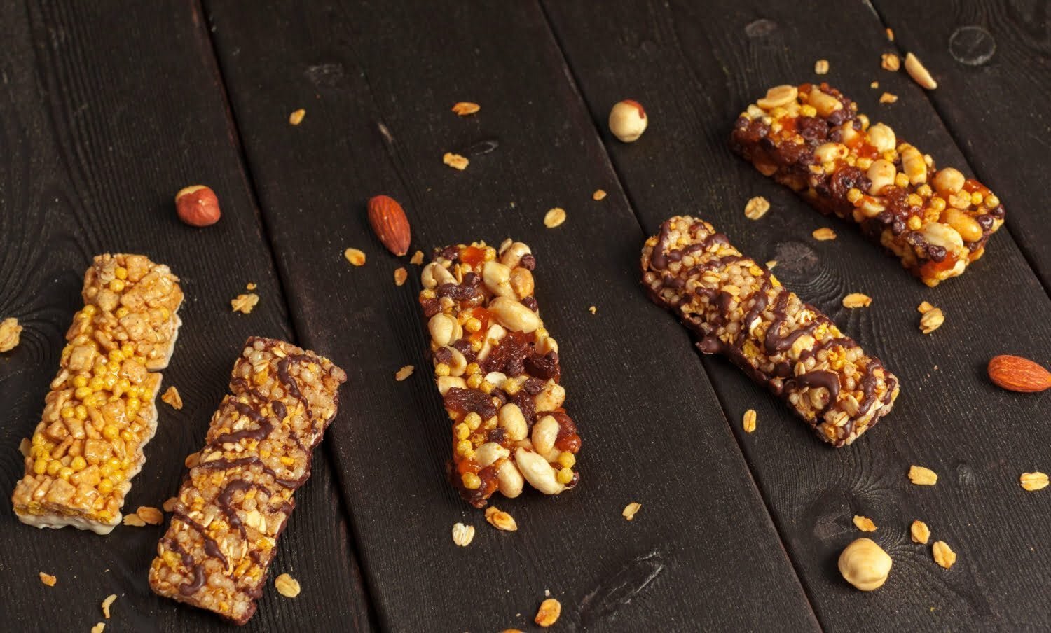 barras de prote&iacute;nas de diferentes sabores, sobre fondo negro