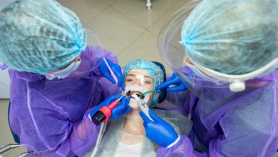 Dentistas realizando cirug&iacute;a bucal a paciente
