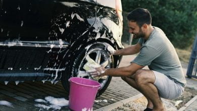 Hombre lavando auto con una esponja y espuma en el patio de la casa / lavar tu carro