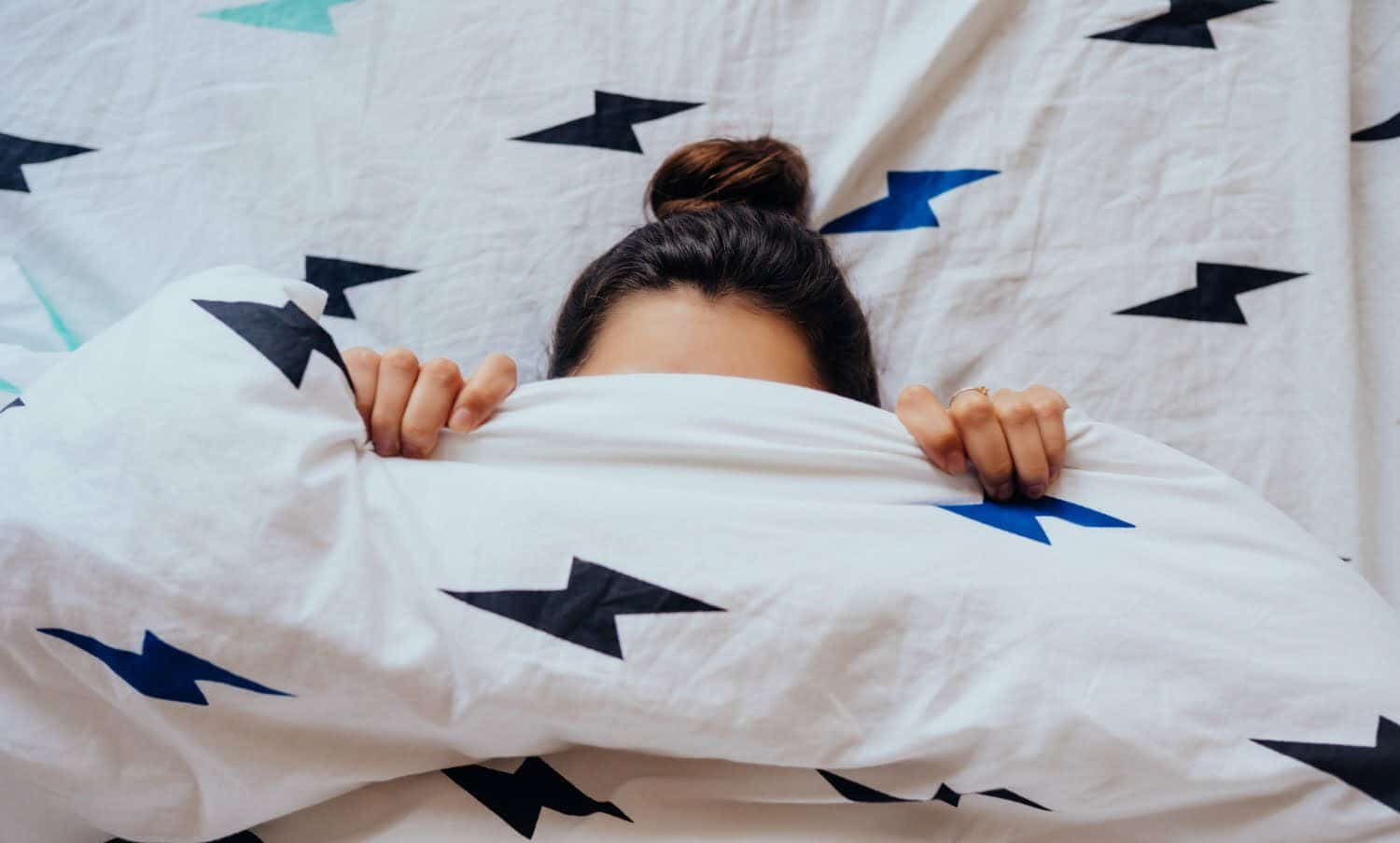 joven que le cuesta madrugar, tapada con las sábanas