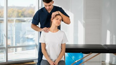 Quiropr&aacute;ctico atendiendo a una mujer por dolor en su cuello