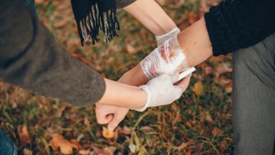 persona aplicando tips de primeros auxilios curando una herida de otro.