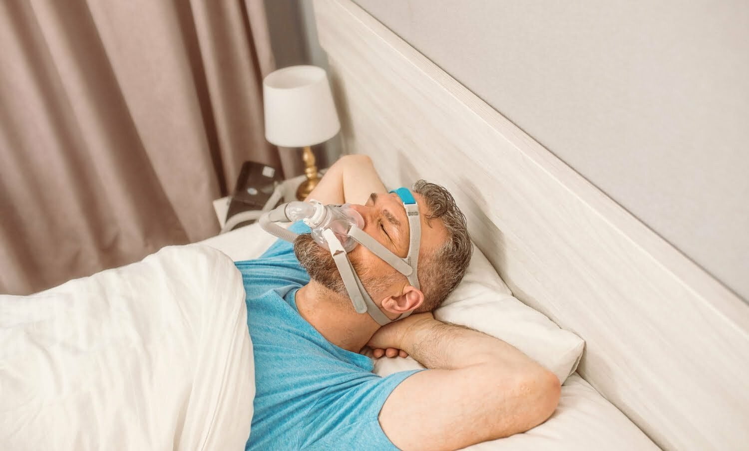 hombre durmiendo con m&aacute;scara respiratoria porque sufre de apnea del sue&ntilde;o