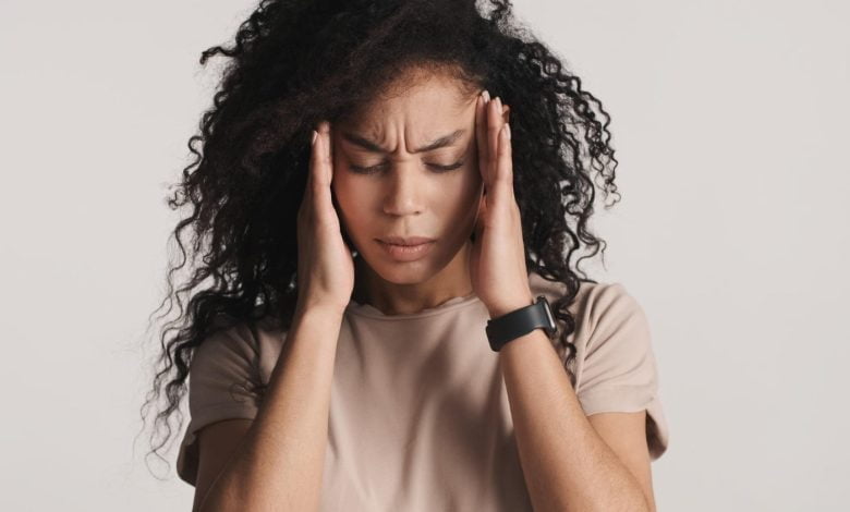mujer tocando su cabeza por causa de migra&ntilde;a / ardor en la cabeza