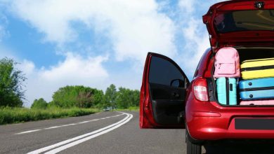 Coche familiar con maletero abierto lleno de equipaje en la carretera. / viajes por carretera / kit básico para viajar por carretera / fin de año requisito