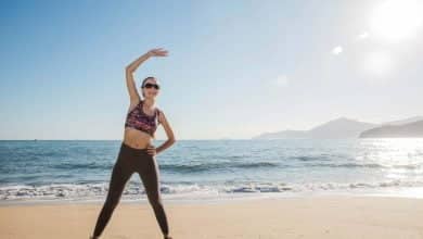 mujer haciendo ejercicio en playa durante sus vacaciones