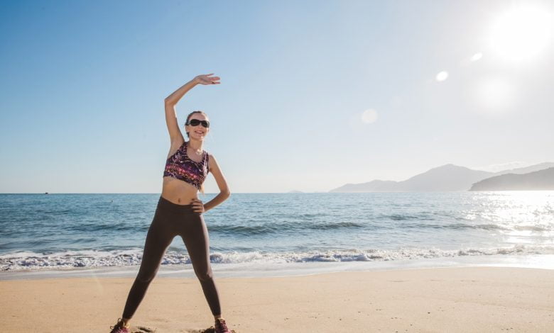 mujer haciendo ejercicio en playa durante sus vacaciones