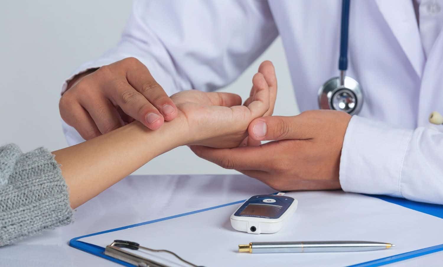 Doctor revisando en paciente signos de aparici&oacute;n de diabetes / sentado