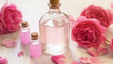 Aceite de rosa en botellas de vidrio con flores rosas / agua de rosas