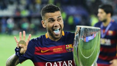 dani alves posa con el uniforme del FC barcelona y una copa