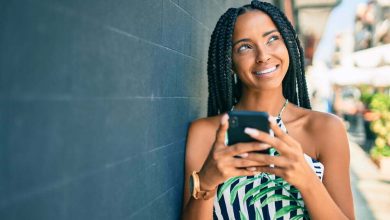 joven sonriendo feliz usando un smartphone en la ciudad/inteligente