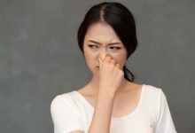 mujer asiática cubriendo su nariz por mal olor / mal olor corporal