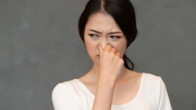 mujer asi&aacute;tica cubriendo su nariz por mal olor / mal olor corporal / malos olores corporales