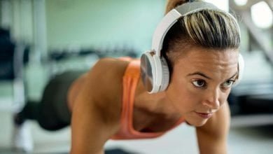 Primer plano de mujer con audífonos puestos para escuchar música mientras hace ejercicio | hacer ejercicio