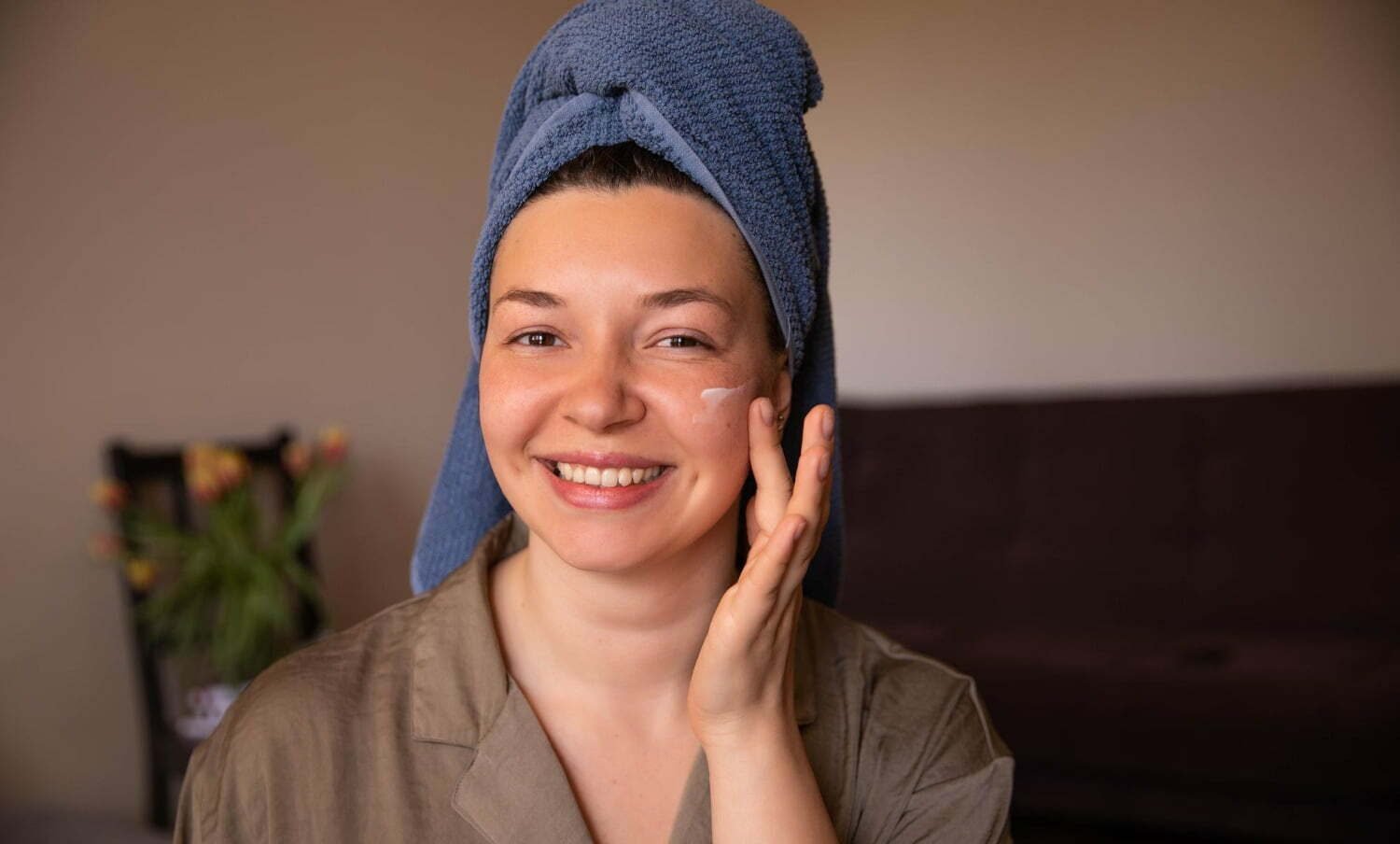 mujer hidratando su piel seca de la cara base de maquillaje / cuidar la piel