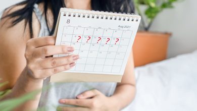 calendario de la mano de la mujer con signo de interrogaci&oacute;n a la espera de un per&iacute;odo sangu&iacute;neo tard&iacute;o / estr&eacute;s menstruaci&oacute;n / sangrado menstrual - sangrado