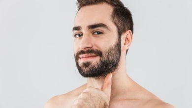 joven guapo sin camisa barbudo que se encuentran aisladas sobre blanco barba so&ntilde;ada