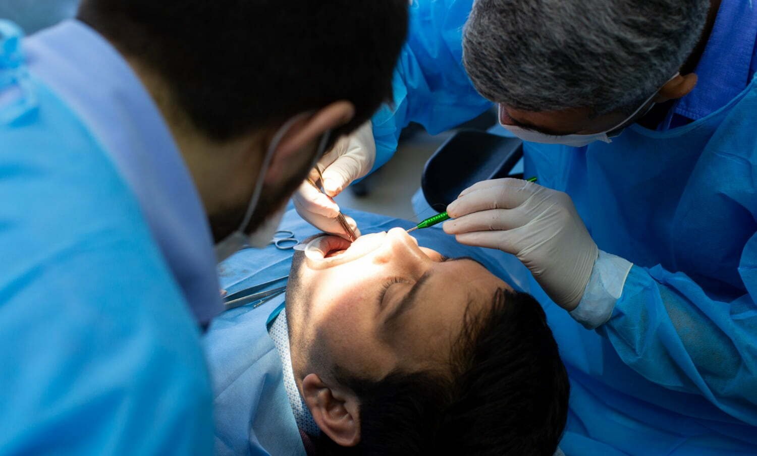 Odontólogo realizando cirugía oral a paciente cuerpo