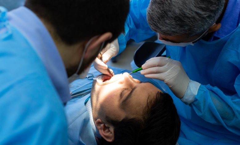 Odontólogo realizando cirugía oral a paciente