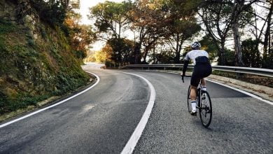 hombre ciclista en bicicleta en la carretera / lesiones en las rodillas