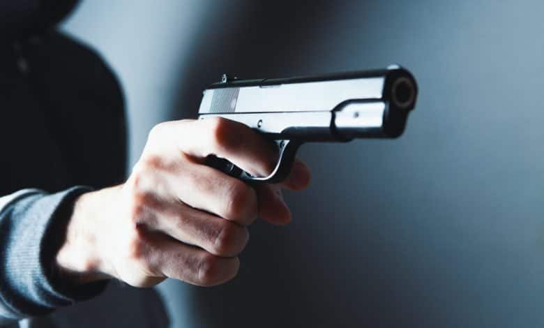 hombre sostiene una pistola en sus manos y amenaza / hurto masivo / robo frustrado