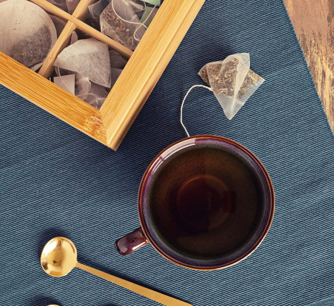 Tetera y taza de té con bolsitas de té de hierbas que contienen cafeína