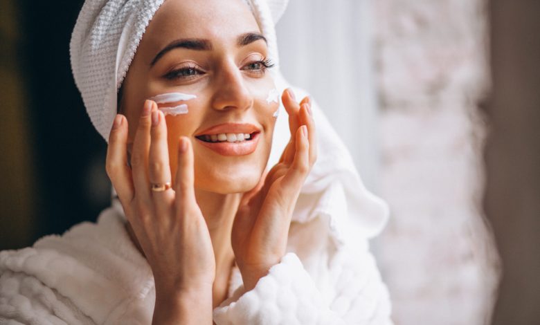 mujer aplicando productos para el cuidado de la piel