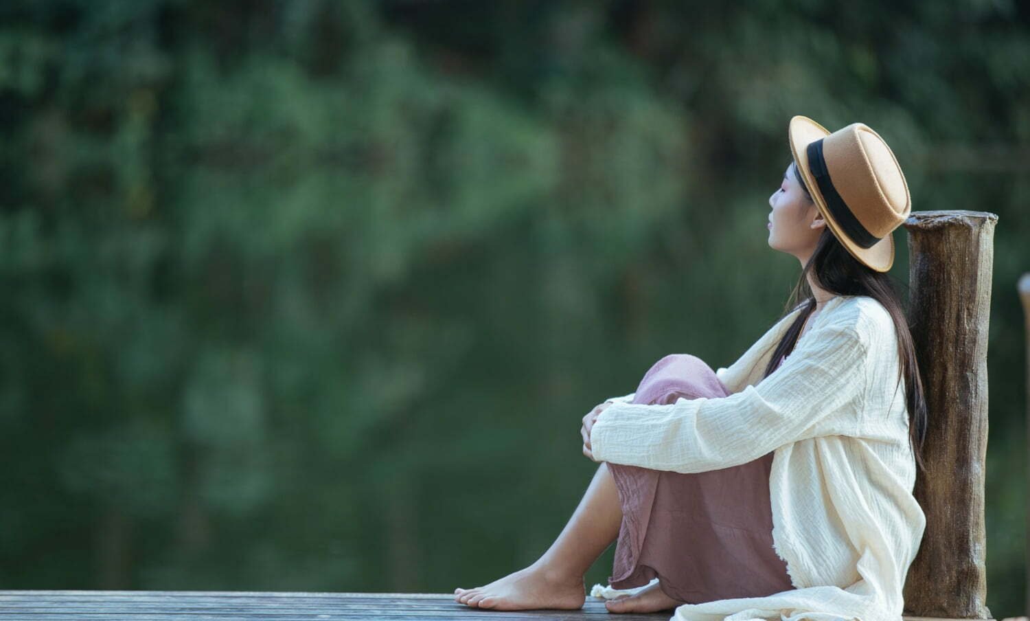 mujer en soledad sentada en una balsa frente al mar