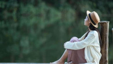 mujer en soledad sentada en una balsa frente al mar