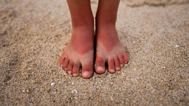 pies de niña sobre la arena insolación