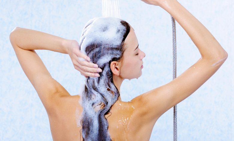 mujer lavando su cabello con el shampoo adecuado