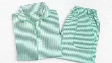 Pajama plegada de color neo-menta a rayas sobre una superficie de madera blanca / cambiar las pijamas / calor