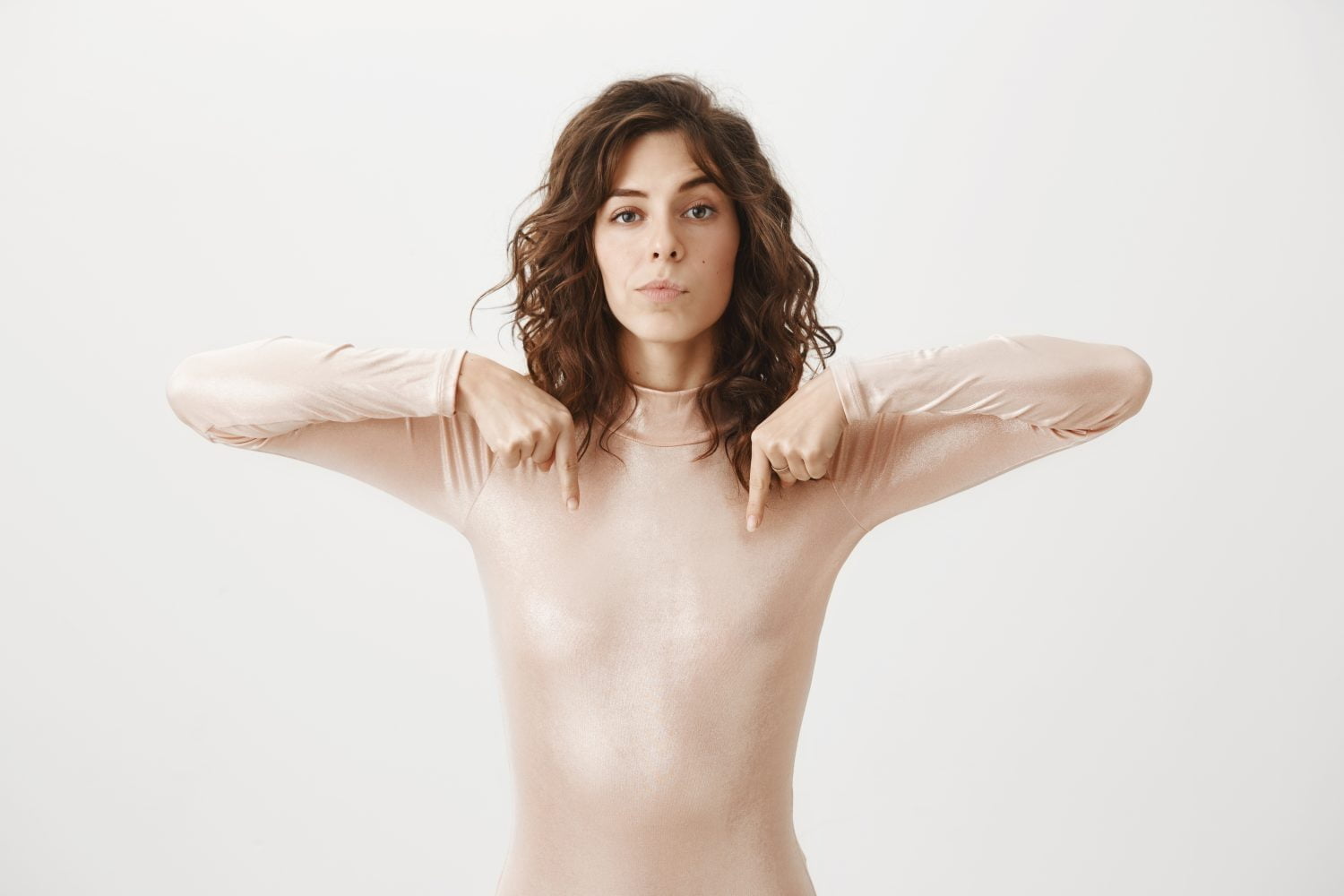 mujer se&ntilde;ala sus senos con dos de sus dedos