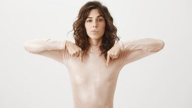 mujer se&ntilde;ala sus senos con dos de sus dedos