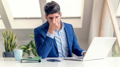 hombre de negocios exhausto con las manos en la frente sentado en la oficina / gafas para usar el computador