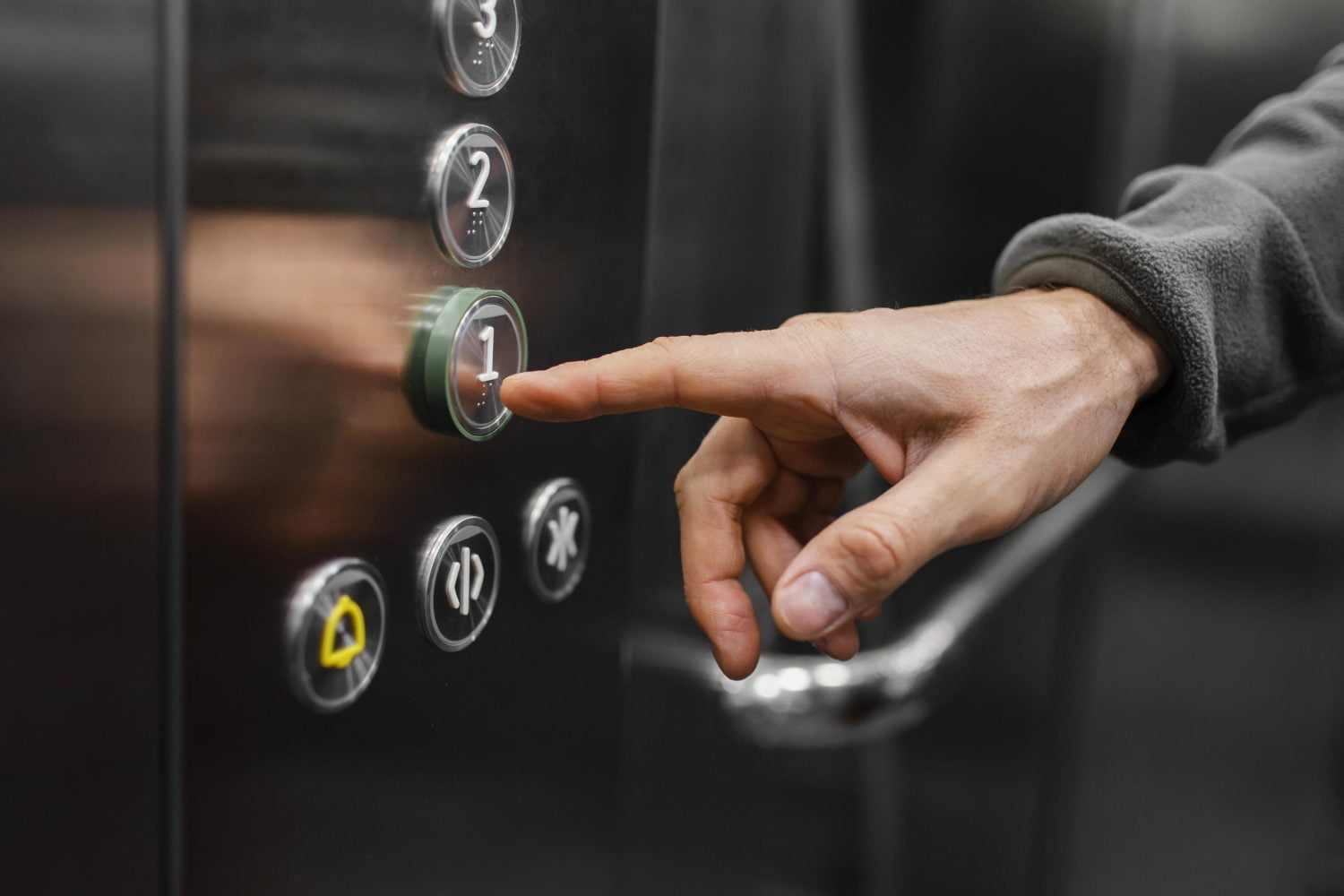 mano tocando los botones de un ascensor