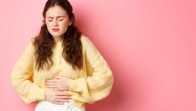 mujer joven con dolor en su estómago por aparición de gastritis período menstrual osteopatía licencia menstrual