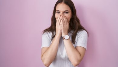 ri&eacute;ndose avergonzada cubriendo la boca con manos / re&iacute;r causa arrugas