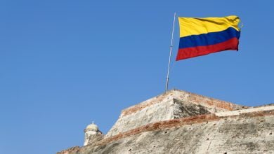 Una bandera colombiana ondea al viento sobre los muros erosionados de la fortaleza del Castillo San Felipe de Barajas en Cartagena de Indias, Colombia / Colombia / florero de Llorente / colombia
