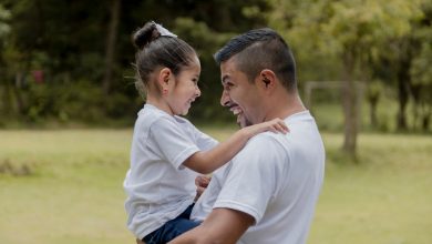 Padre hispano abrazando a su peque&ntilde;a hija en el parque / d&iacute;a del padre