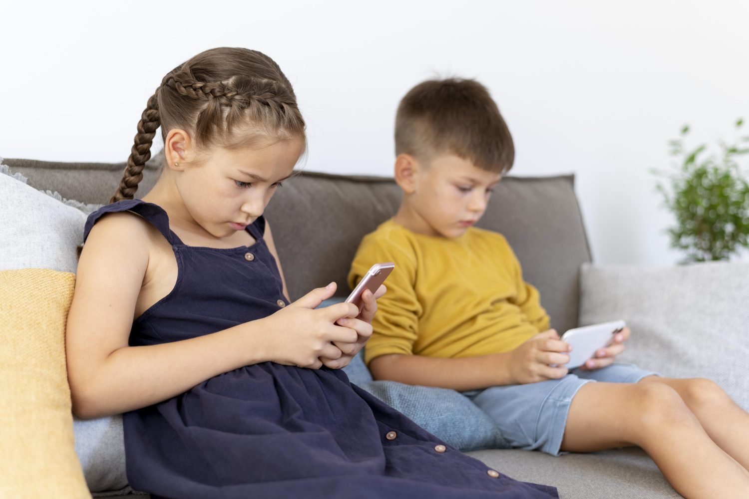 niños de tiro medio con dispositivos en interiores redes sociales / edad para darle a un niño su primer celular