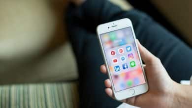 usando un tel&eacute;fono inteligente con &iacute;conos de las redes sociales en la pantalla / pedofilia